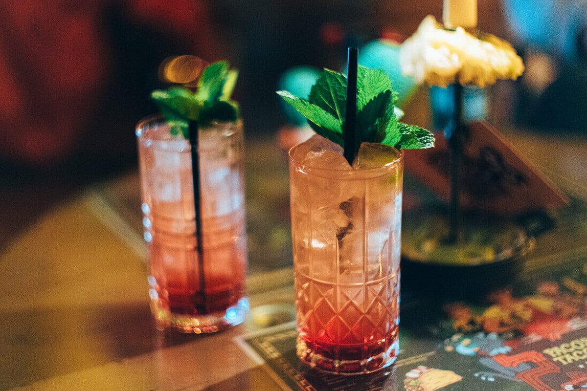 Cocktail im Longdrinkglas mit Eiswürfeln und Minze